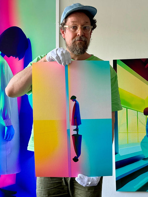 Contemporary and colorblind artist Kalle Hellzén is holding a fine art print limited edition of his colorful artwork Private Sun