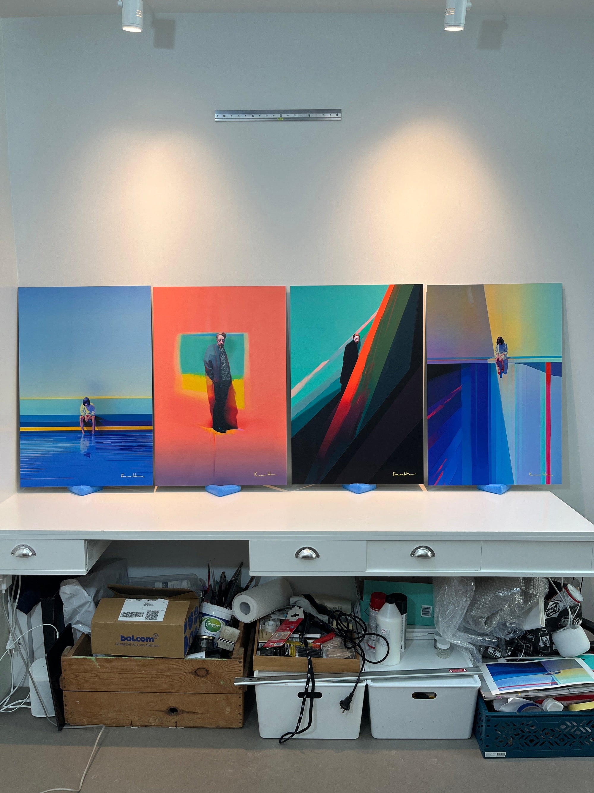 Studio overview of four large unframed aluminium-mounted prints by Atelier Kalle Hellzén displayed side by side on a work table under track lighting.