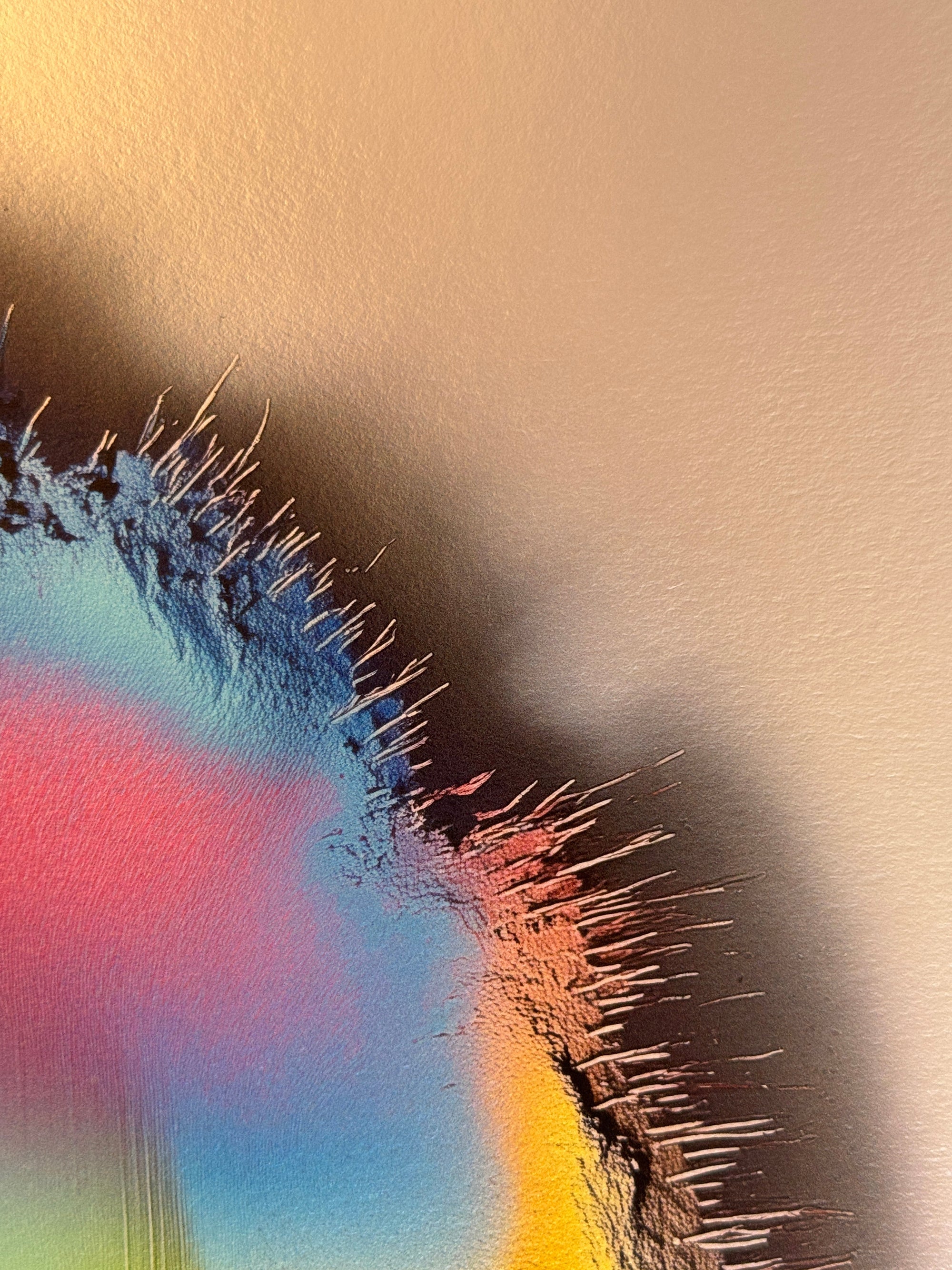 IMPACT 0016, close crop of the ragged edge where blue-black fringe threads fray against cream paper, with pink, red, and orange colour visible through the torn opening below the disc's rim.