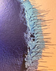 IMPACT 0016, close crop of the ragged edge where deep indigo blue meets a pale turquoise band, both fraying into thin blue-black threads against warm gold paper.
