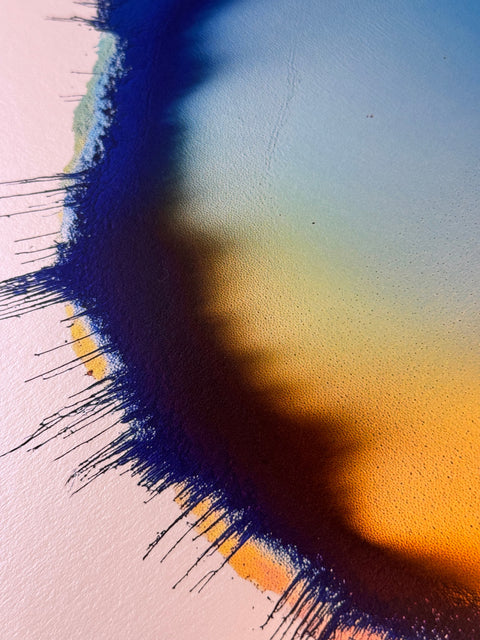 IMPACT 0017, close crop of the upper edge showing dark navy fringe at left, with a soft blue, green, and orange gradient on the paper crossed by a diagonal shadow from the disc's raised rim.
