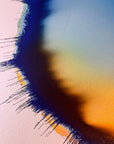 IMPACT 0017, close crop of the upper edge showing dark navy fringe at left, with a soft blue, green, and orange gradient on the paper crossed by a diagonal shadow from the disc's raised rim.