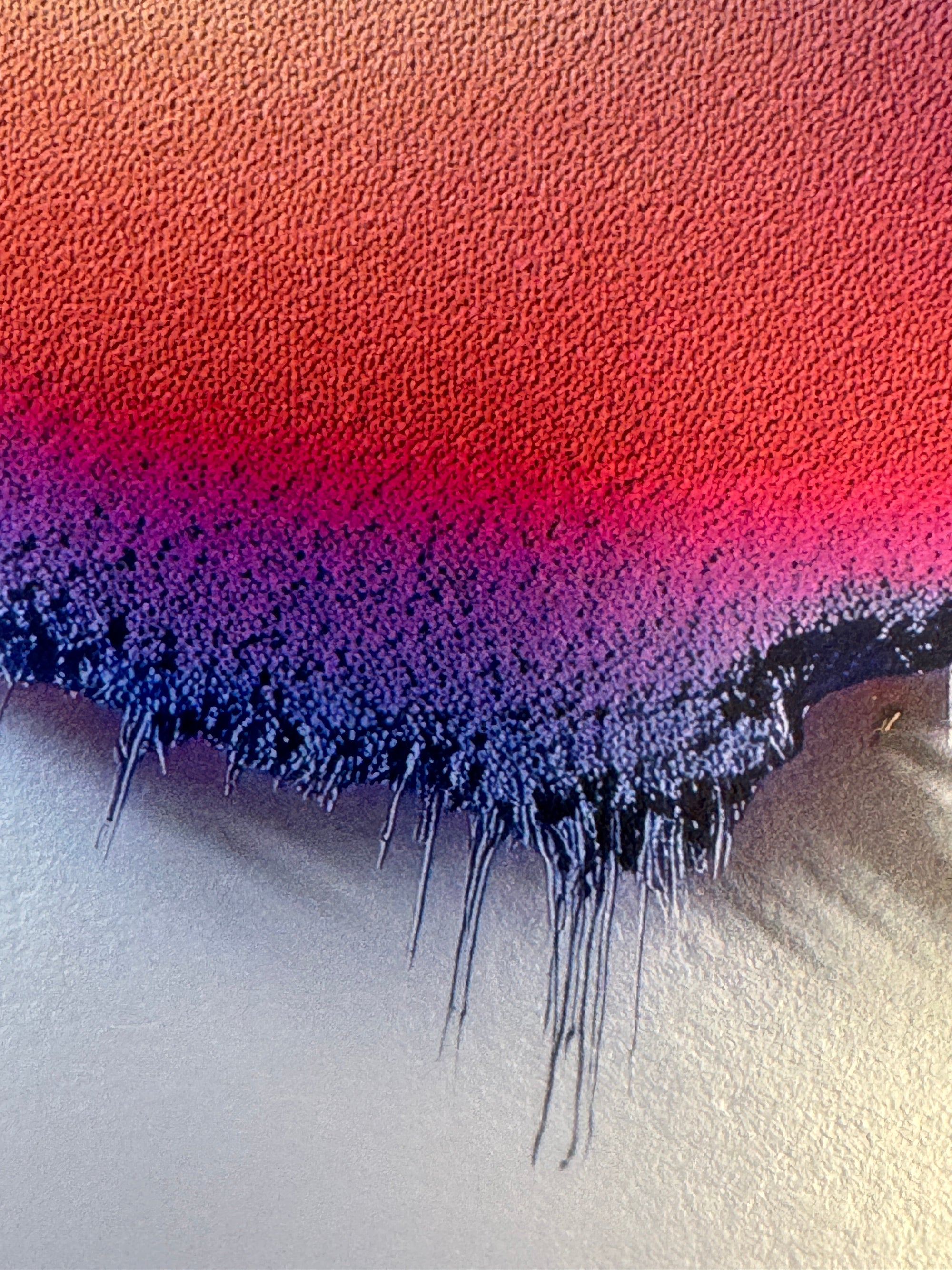 IMPACT 0017, close crop of the disc's lower edge where a red field deepens to magenta and purple before fraying into blue-black threads that drip down onto the plain cream paper below.