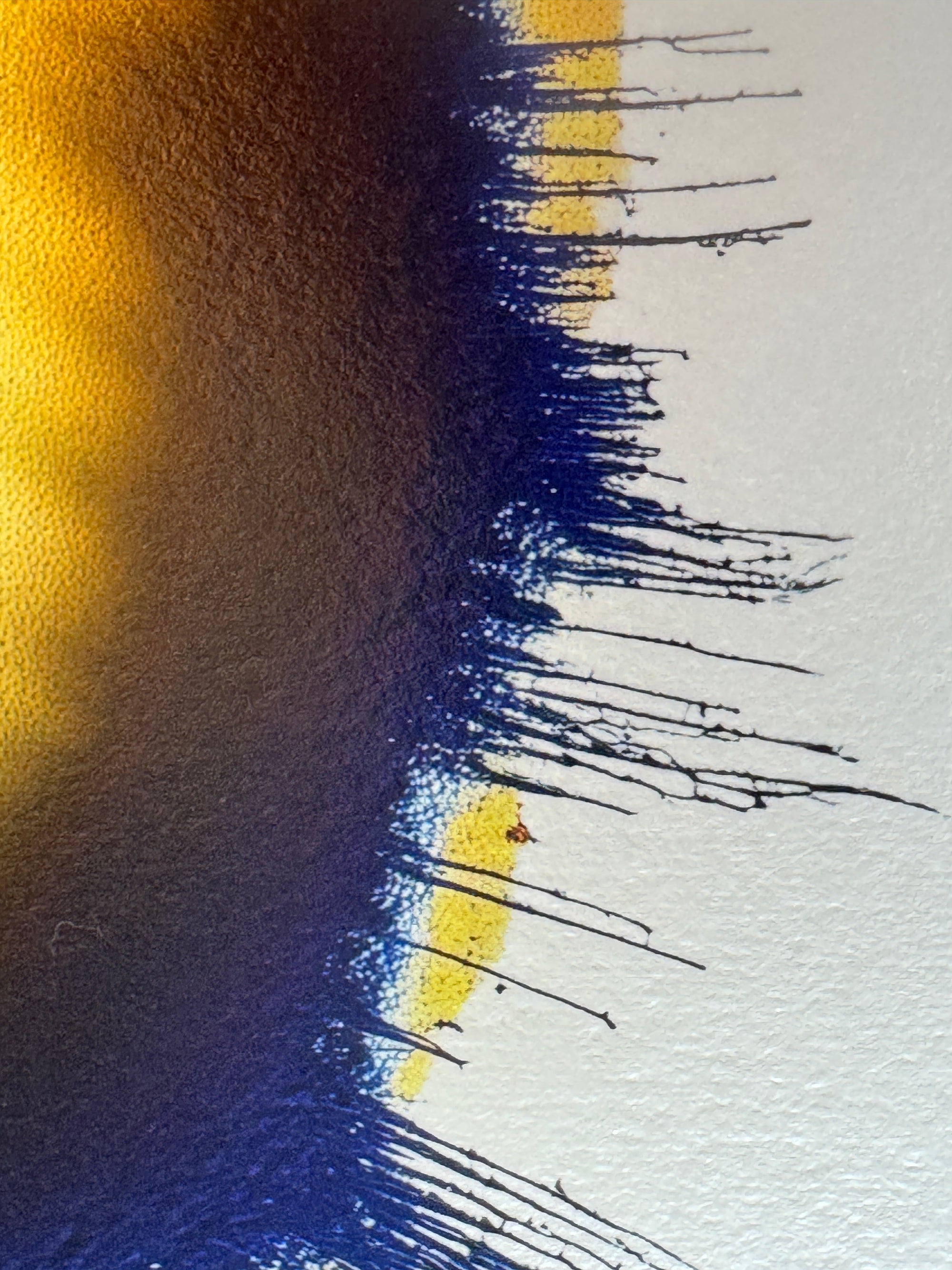 IMPACT 0017, close crop of the ragged edge where a navy-blue fringe of fine threads drips down from a gold field at left, with small yellow patches breaking through onto the cream paper at right.
