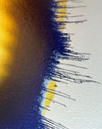 IMPACT 0017, close crop of the ragged edge where a navy-blue fringe of fine threads drips down from a gold field at left, with small yellow patches breaking through onto the cream paper at right.