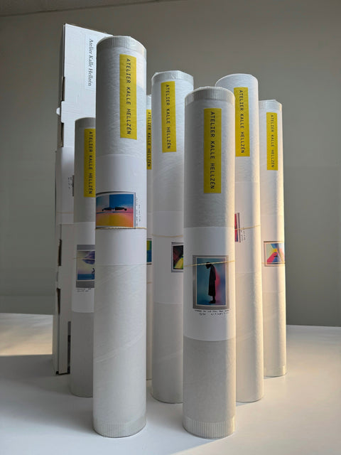 Rolled prints in white shipping tubes with yellow Atelier Kalle Hellzén labels, each with a small picture of the work