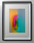 What Comes Back by Atelier Kalle Hellzén, hand-signed and numbered Limited Edition of 5, shown in a black frame on a pale wall. The deckle-edged sheet floats inside the mount, the saturated figure held against the dark surround. Giclée on handmade kozo washi.