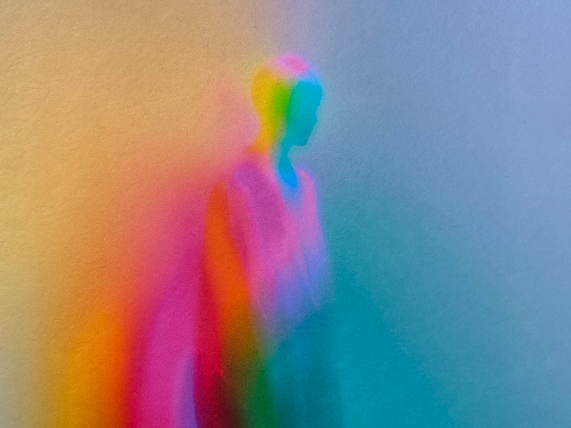 What Comes Back by Atelier Kalle Hellzén, a wide view of the figure's head and shoulders dissolving into a field of orange, pink and teal, the colour reading as pressure across the form. Giclée on handmade kozo washi.