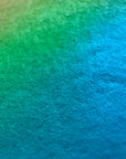 Surface detail of What Comes Back by Atelier Kalle Hellzén, the pigment reading as bands of orange, pink and teal across the visible fibre of the handmade sheet, with no figure in frame. Giclée on handmade kozo washi.